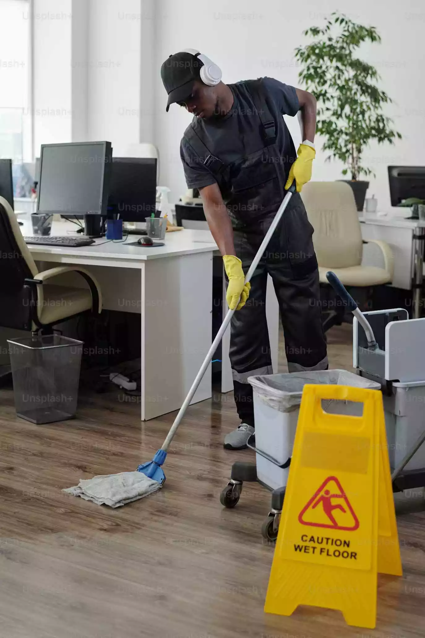 Person cleaning and drying the floor in an office