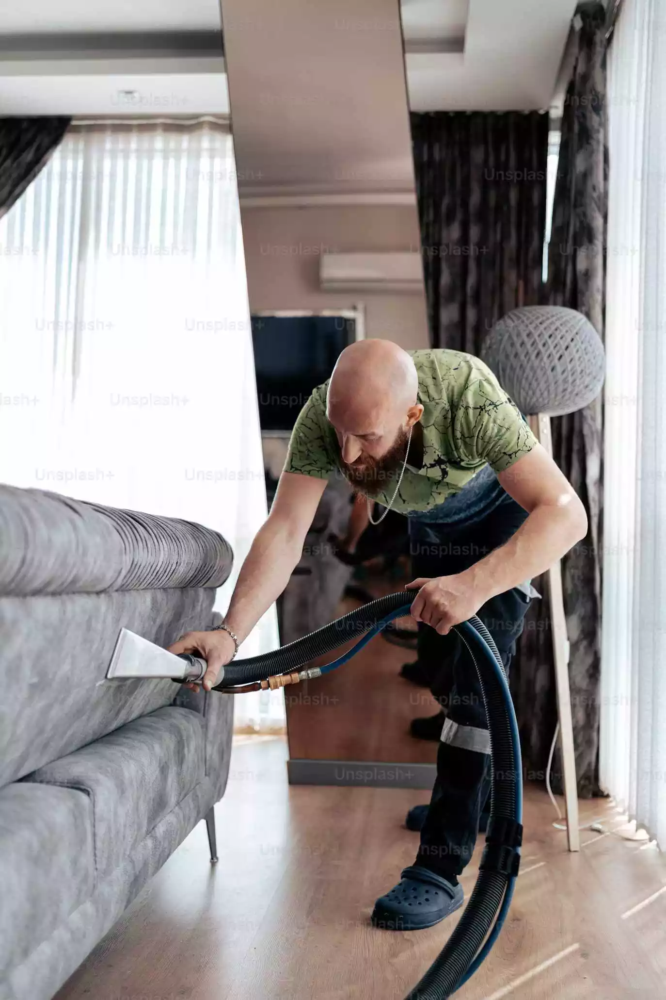 Person cleaning a sofa full of fluff with a vacuum cleaner