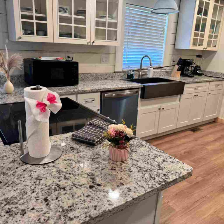 Pristine kitchen with gleaming granite countertops, spotless appliances, shining farmhouse sink, and streak-free glass cabinets showcasing expert kitchen cleaning services in Charlotte and Raleigh North Carolina
