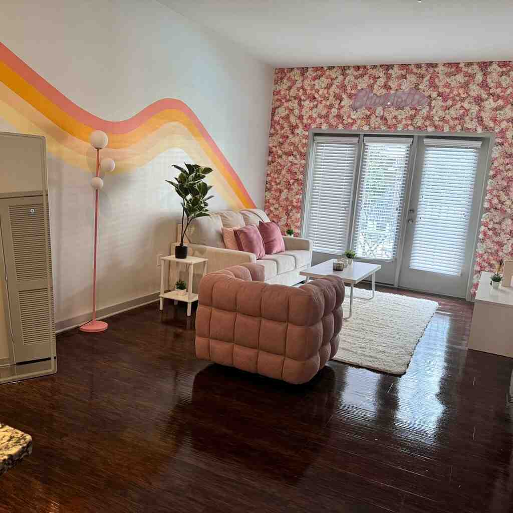 Elegant living space featuring polished hardwood floors, unblemished floral accent wall, crystal-clear window treatments, and meticulously maintained furniture exemplifying premier residential maintenance solutions in Raleigh and Charlotte NC